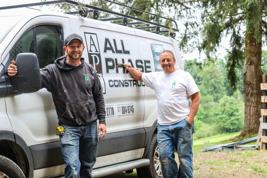 “All Phase Construction LLC contractors standing by company van on job site in Longview WA providing residential and commercial construction services
